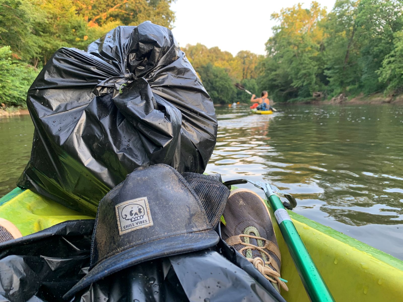 a canoe carries bags of trash